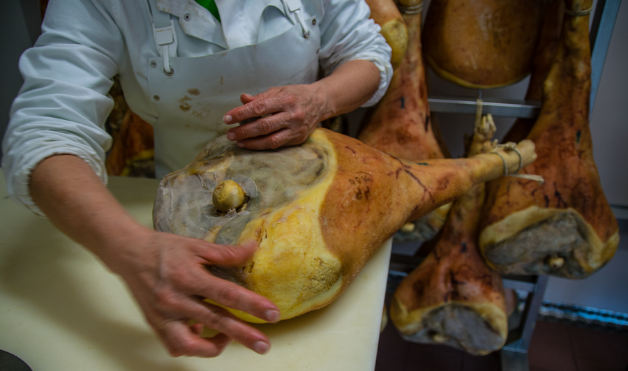 La tecnica della sugnatura che prevede l’applicazione di un impasto sulla cotenna scoperta del prosciutto.